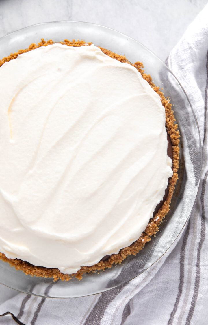 Whipped cream on top of a chocolate pie.
