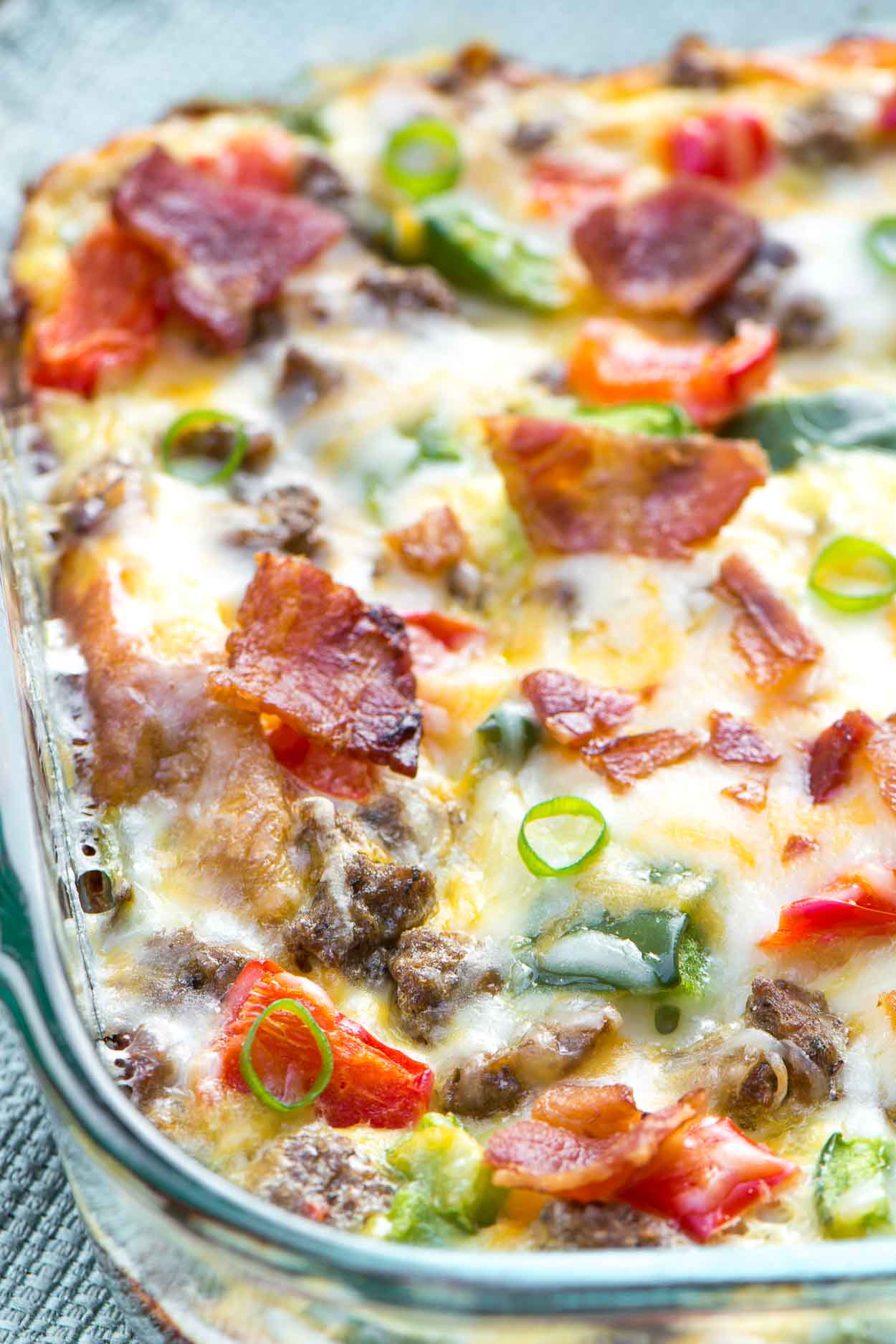 A healthy, fully loaded breakfast casserole topped with fresh veggies, meats and blends of cheeses. Breakfast is served! www.simplerevisions.com