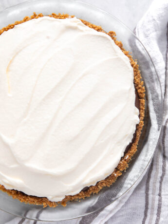 Whipped cream on top of a chocolate pie.