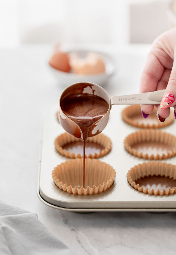 Chocolate cupcake batter poured into a lined muffin tin.
