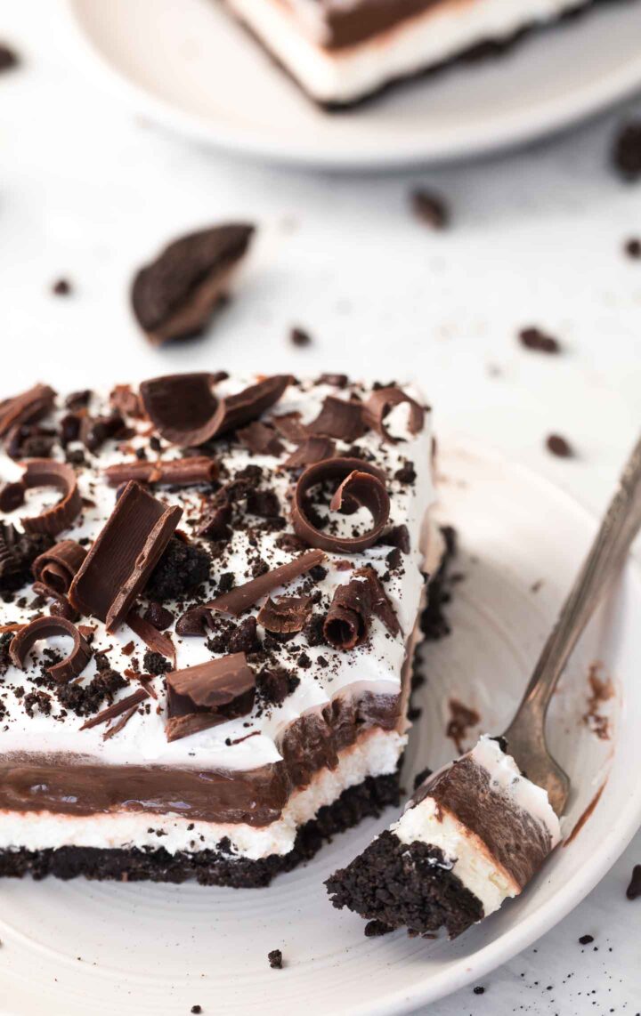 Chocolate Lasagne on a white plate with fork with a bite of the dessert.