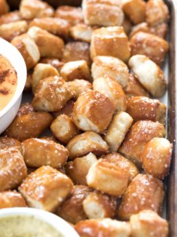 soft pretzel bites on a tray with a small white bowl of nacho cheese sauce