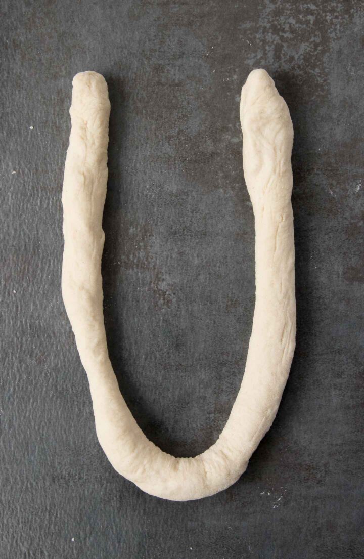 Pretzel dough shaped into a 'U'.