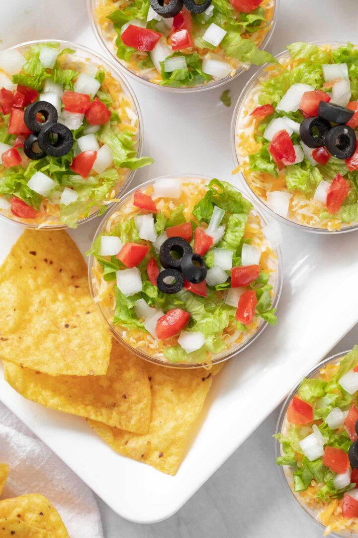 7 layer dip cups on a serving tray 