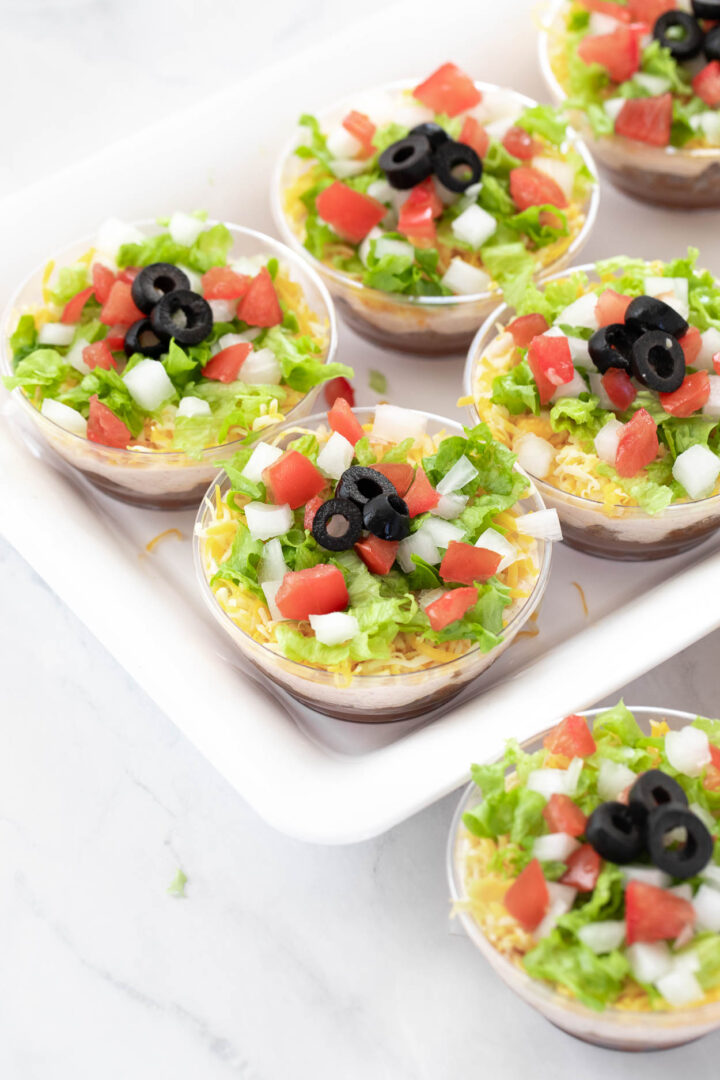 7 layer dip cups on a plate